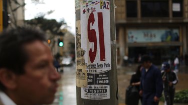 A man walks past a campaign poster for a 'Yes' vote, written 'Si' in Spanish, on the peace referendum in Bogota.