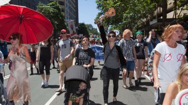 Amanda Palmer joins marchers in Sydney, holding her ukulele aloft. 