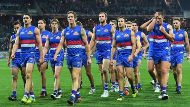 Body language: Dejected Bulldogs leave the ground after the loss to the Cats.