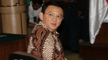 Jakarta governor Ahok, sits on the defendant's chair at the start of his trial.
