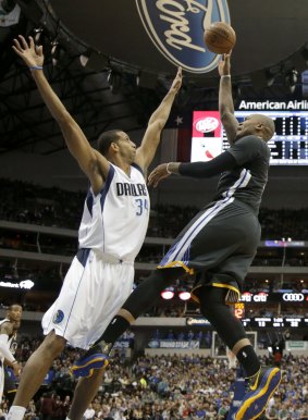 Dallas Mavericks forward Brandan Wright (left) defends against a shot by Golden State Warriors' Marreese Speights in the first half of Saturday's game in Dallas.