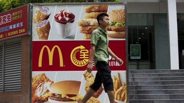 A pedestrian walks past an advertisement for McDonald's in the Futian district of Shenzhen, China, where sales have been hit hard after a McDonald's supplier was accused of repackaging old meat. 