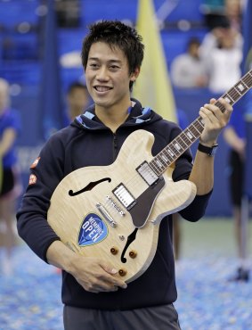 Kei Nishikori poses with his guitar trophy.