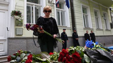 A woman lays flowers in front of the British Embassy in Kiev, Ukraine.