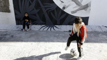 Children play at the Hellenikon shelter, a former Olympic  hockey venue, in southern Athens. A tightening of border controls closer to the promised lands of Germany and Sweden has left thousands trapped and destitute in Greece.