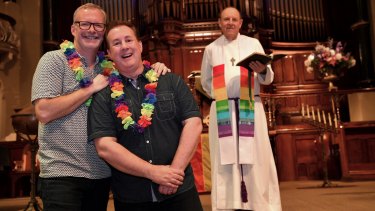 Reverend Ric Holland of St Michael's in Collins Street, with couple Matthew Jones, left, and Jonathon Welch, has called on Uniting Church to start same sex marriages sooner.