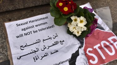 A banner with flowers is placed on the steps to the Cologne cathedral says in English and Arabic "sexual harassment against women will not be tolerated". 