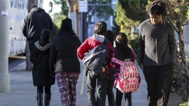 Parents take their children back home on Tuesday after the threat closed schools across Los Angeles.