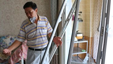 Wang Jiaming surveys the damage in his apartment, over a kilometre from the blast site in Tianjin.