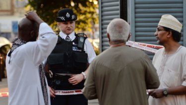 A police officer talks to Finsbury Park locals near the scene where a van hit pedestrians.