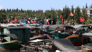 Fishing vessels moored at Tanmen wharf fly the flag of the People's Republic.