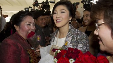 Thailand's former Prime Minister Yingluck Shinawatra receives flowers from her supporters on Thursday.
