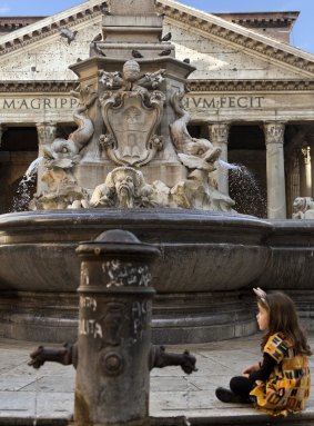 A child sits next to the Fountain of the Pantheon in downtown Rome, on Tuesday. The fountain is among the monuments up for "adoption".