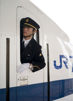  Shinkansen Bullet train conductor checks the platform as the train pulls out of Osaka station bound for Tokyo.