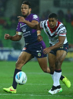 The Storm's Will Chambers and Michael Jennings of the Roosters chase the ball at AAMI Park on Saturday night. 