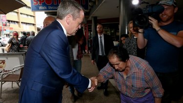 A woman bows to Mr Shorten during a street walk in Campbelltown, NSW. 
