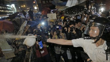 Chemical agent: A police officer uses pepper spray against protesters at an occupied area in Mong Kok district of Hong Kong.
