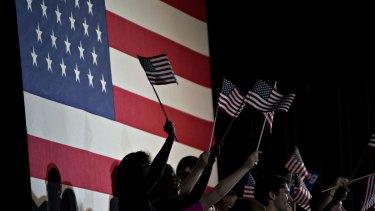 Supporters wave American flags during a Super Tuesday rally for Hillary Clinton.