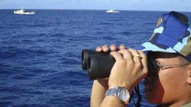 A crewman from a Vietnamese coastguard ship watches Chinese coastguard vessels  in the South China Sea last year.  Japan is forging naval security ties with the Philippines and Vietnam in a bid to counter Chinese moves.