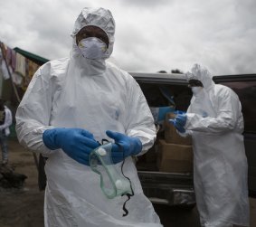 An ambulance team prepares to collect a body suspected of being infected with Ebola.