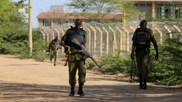 Kenya Defence Force soldiers patrol the perimeter wall where the Islamists are holding hostages and executing Christians at a campus in Garissa.