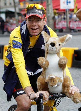 After winning the Tour de France in 2011, Cadel Evans cycles down the Champs-Elysees during the victory parade in Paris. 