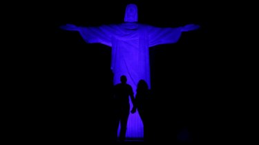 The statue of Christ the Redeemer is lit blue in Rio de Janeiro.  