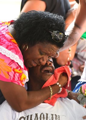 Grief-stricken: Family members mourn at the scene of a memorial in the park next to the home of seven of the eight children slain. 