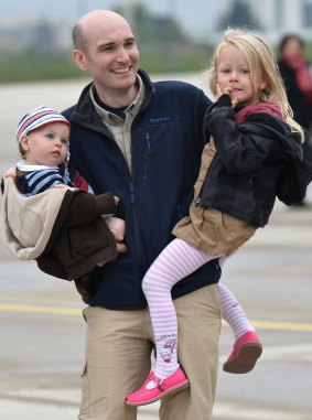 Nicolas Hénin holds his children at a military base in France in April 2014 after being freed from IS captivity.