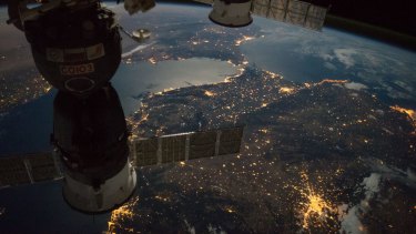 The International Space Station camera captures a nighttime view of the Strait of Gibraltar with a Russian Soyuz spacecraft (left) and Progress spacecraft in the foreground. You can see the lights of Madrid and Valencia bottom of frame with Rabat and Casablanca towards the top.