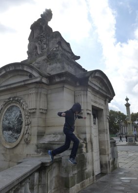 A teenager tries parkour in Paris.