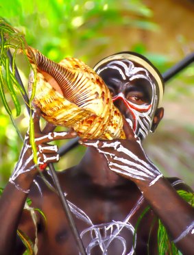 Trobriand Island warrior blows on a shell horn at Alotau, Papua New Guinea. 
