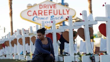Cece Navarrette sits near a cross for her cousin, Bailey Schweitzer, who was among those killed during the mass shooting in Las Vegas.