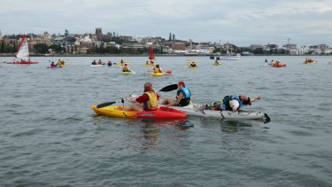 Protesters in kayaks in Newcastle harbour. 