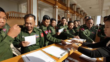 Myanmar military lawmakers sign in to attend the final session of Myanmar's outgoing Parliament as it ended its five-year term on Friday.