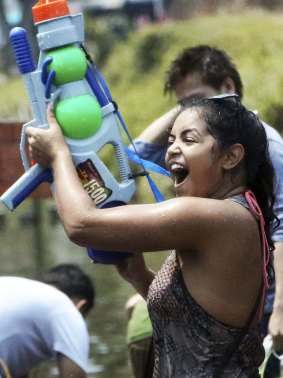 A foreign tourist holds a water gun as she takes part in a water fight during traditional Thai New Year celebrations or Songkran festival in Chiang Mai 