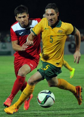 Australia's Mark Milligan (right) vies for the ball with Kyrgyzstan's Mirlan Murzaev, who was a menacing threat throughout the game.