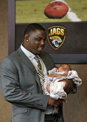 Jackson carries his two-month-old daughter Nahla as he arrives for a press conference after signing with the Jacksonville Jaguars .
