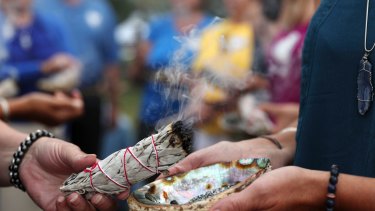 Volunteers take part in a Native American spiritual burning of sage during the memorial service for Justine Damond at Lake Harriet in Minneapolis.