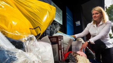 Kerryn Caulfield is urging people to not dump goods outside charity stores. 
Ms Caulfield with donated items left in front of the Salvation Army store on Burwood Road, Hawthorn on Monday. 
