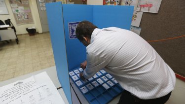 A polling station worker arranges ballots in a voting booth in Tel Aviv.