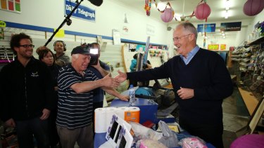 Prime Minister Malcolm Turnbull meets newsagent Tony Higgs at flood clean up operations in Picton, Sydney.