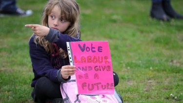 A young girl holds a sign supporting the Labour party.