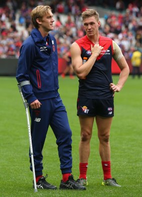 Oscar McDonald talks to his brother Tom after injuring his ankle.