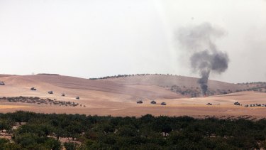 Turkish army tanks move toward the Syrian border as pictured from Karkamis, Turkey.