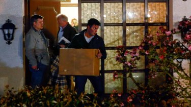 German police carry boxes out of a house believed to belong to the parents of Andreas Lubitz on Thursday.