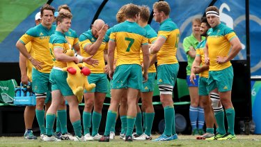 Australian players look dejected in defeat after the Men's Rugby Sevens  match against Argentina.