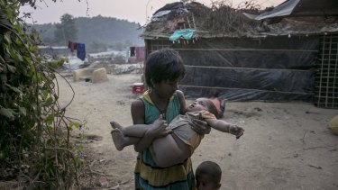 A girl carries a toddler in her arms in Kutapalong Rohingya refugee camp in Cox's Bazar, Bangladesh. 