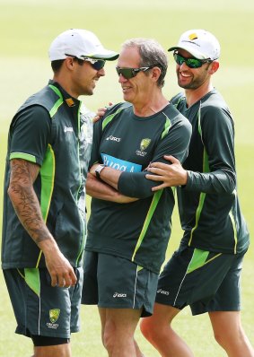 Light-hearted moment: Australian spinner Nathan Lyon hides behind team doctor Peter Brukner after getting paceman Mitchell Johnson in a headlock at training on Monday.