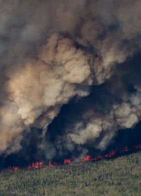 A huge plume of smoke from wildfires   rises over Fort McMurray on Friday.